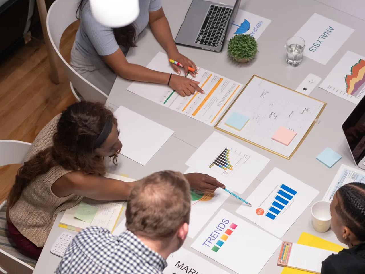 Business team reviewing financial charts and trend data around a table